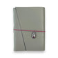 Gray handbound leather notebook with a diagonal fold design, wrapped with a pink elastic cord and featuring a silver-toned scarab charm