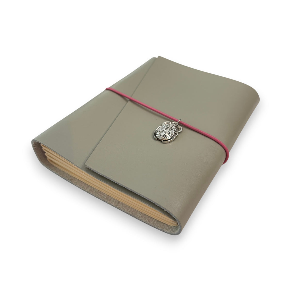 Gray handbound leather notebook with a diagonal fold design, wrapped with a pink elastic cord and featuring a silver-toned scarab charm