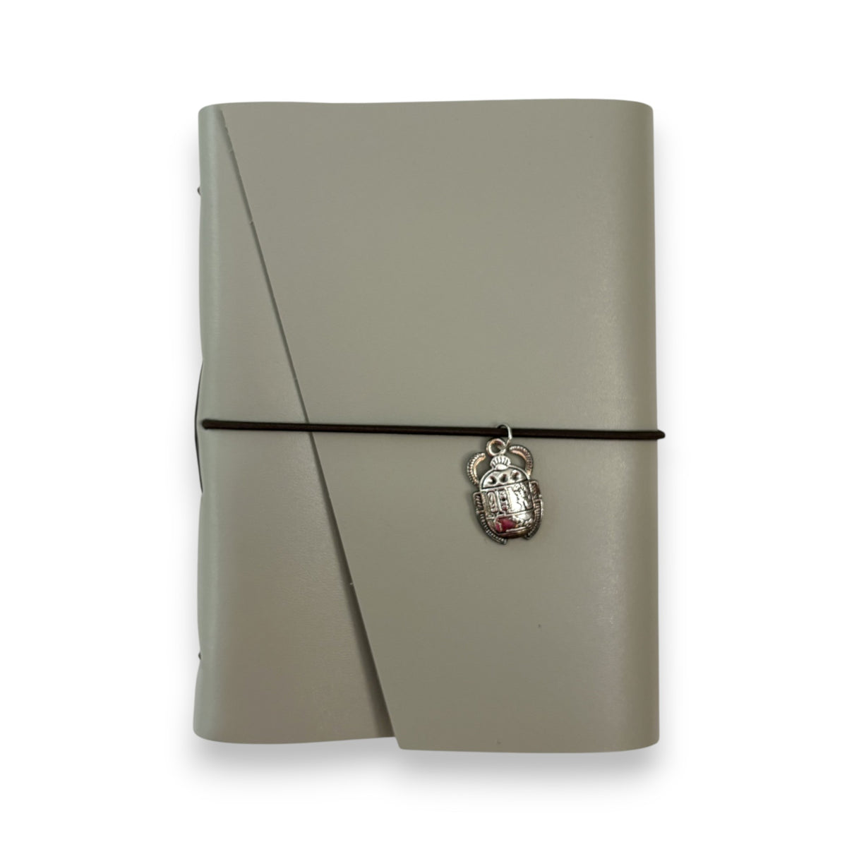 Gray handbound leather notebook with a diagonal fold design, wrapped with a pink elastic cord and featuring a silver-toned scarab charm