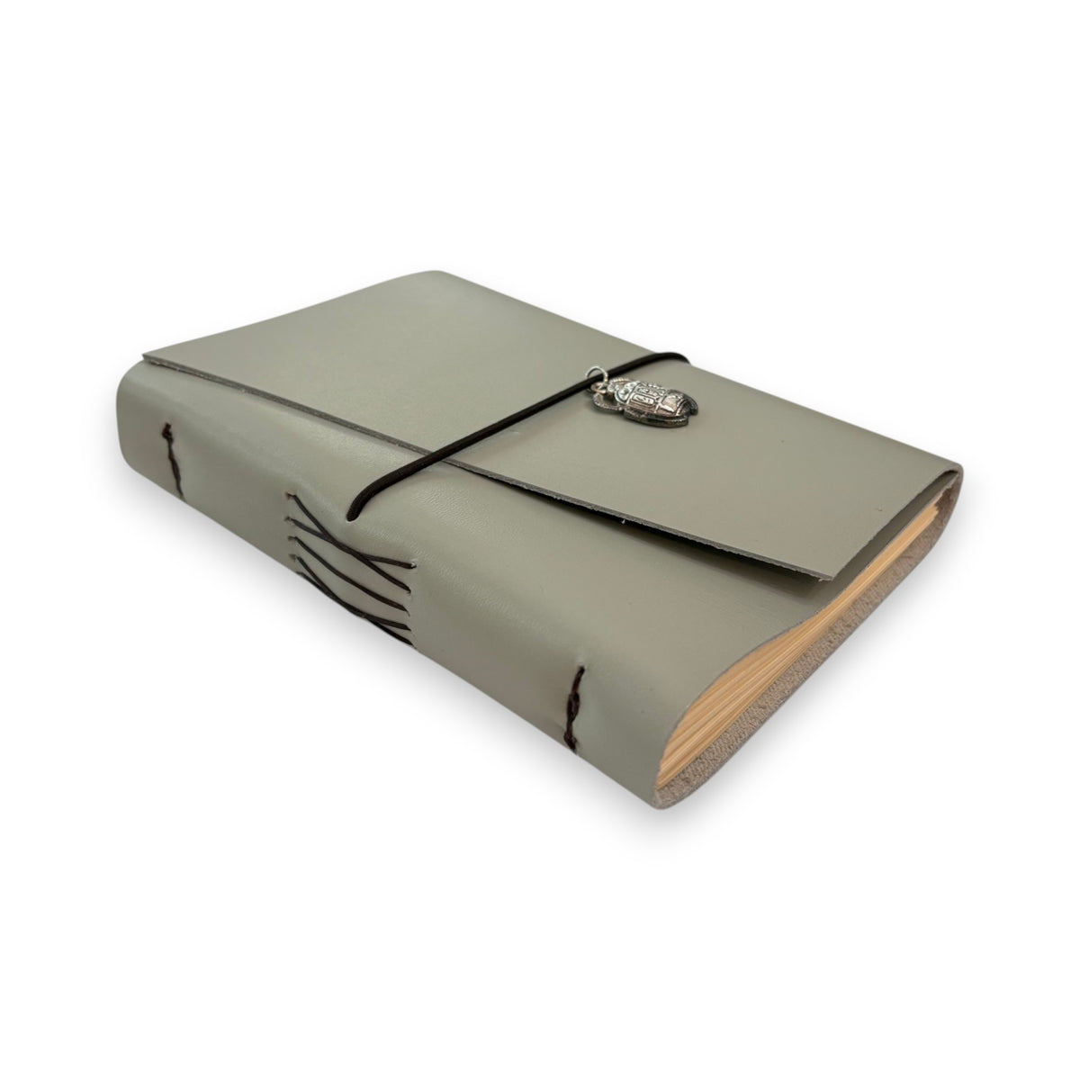 Gray handbound leather notebook with a diagonal fold design, wrapped with a pink elastic cord and featuring a silver-toned scarab charm