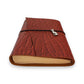 Rust red handbound leather journal with a wrap-around elastic strap and a silver metal cat goddess Bastet Charm