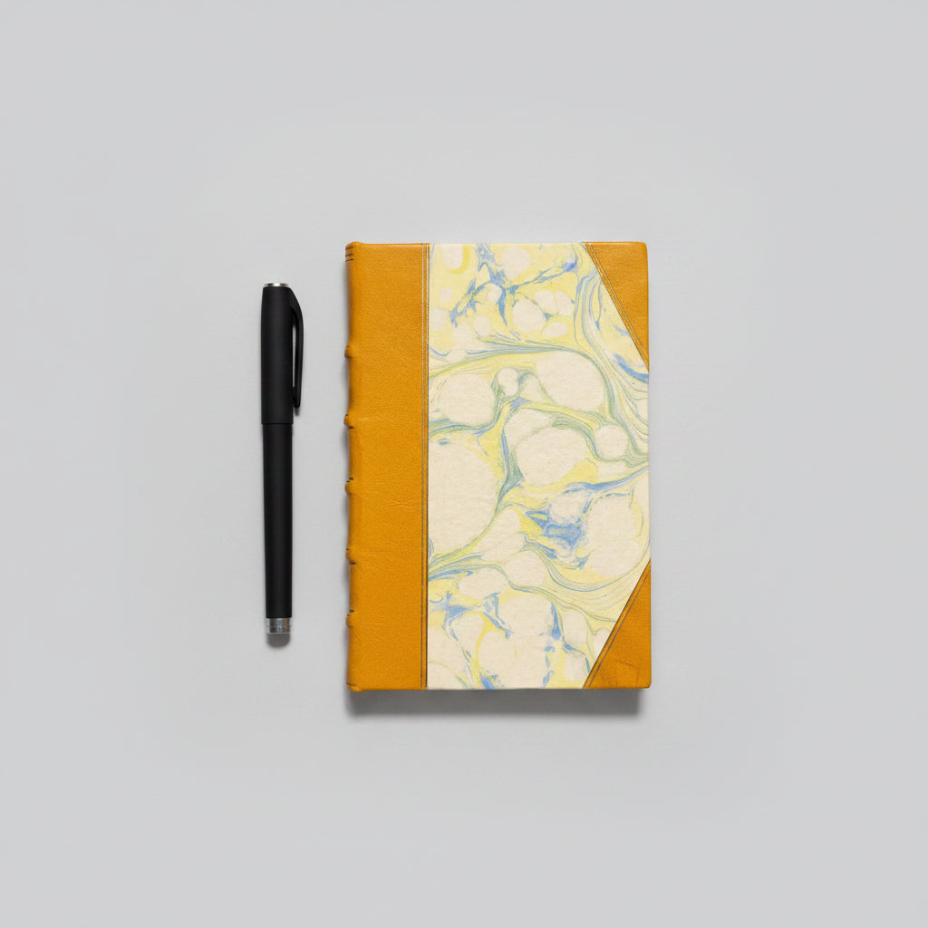 Handmade notebook journal with marbled cover and mustard leather binding