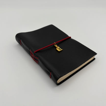 Handcrafted black leather journal with red string and gold Bastet cat charm, cruelty-free, fair trade, ethically handmade