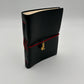 Handcrafted black leather journal with red string and gold Bastet cat charm, cruelty-free, fair trade, ethically handmade