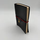 Handcrafted black leather journal with red string and gold Bastet cat charm, cruelty-free, fair trade, ethically handmade