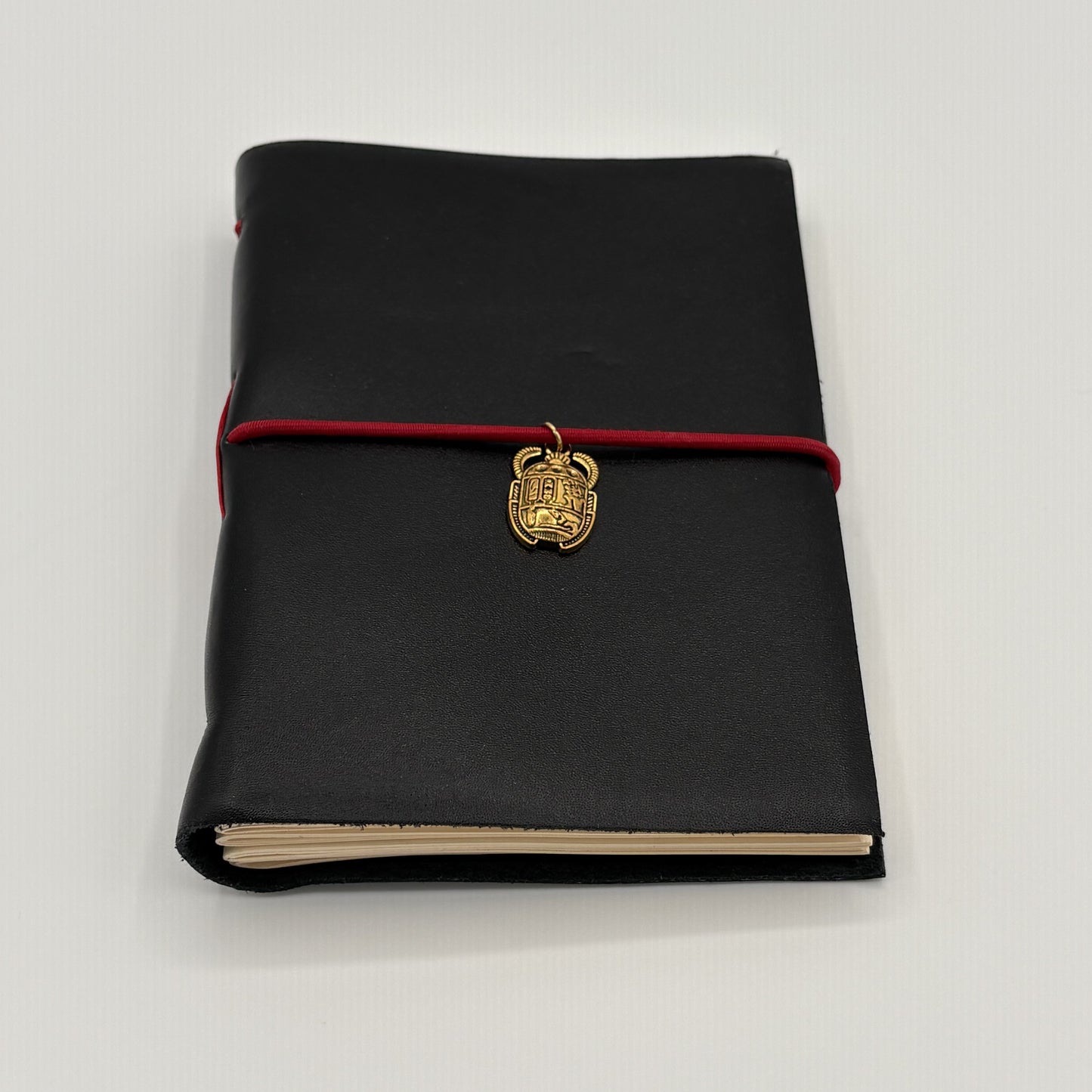 Handcrafted black leather journal with red string and gold Scarab charm, cruelty-free, fair trade, ethically handmade