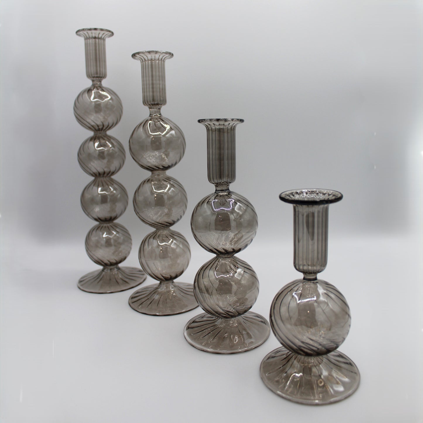 Decorative handblown glass long stem candle holders with baubles in smoky, centerpiece