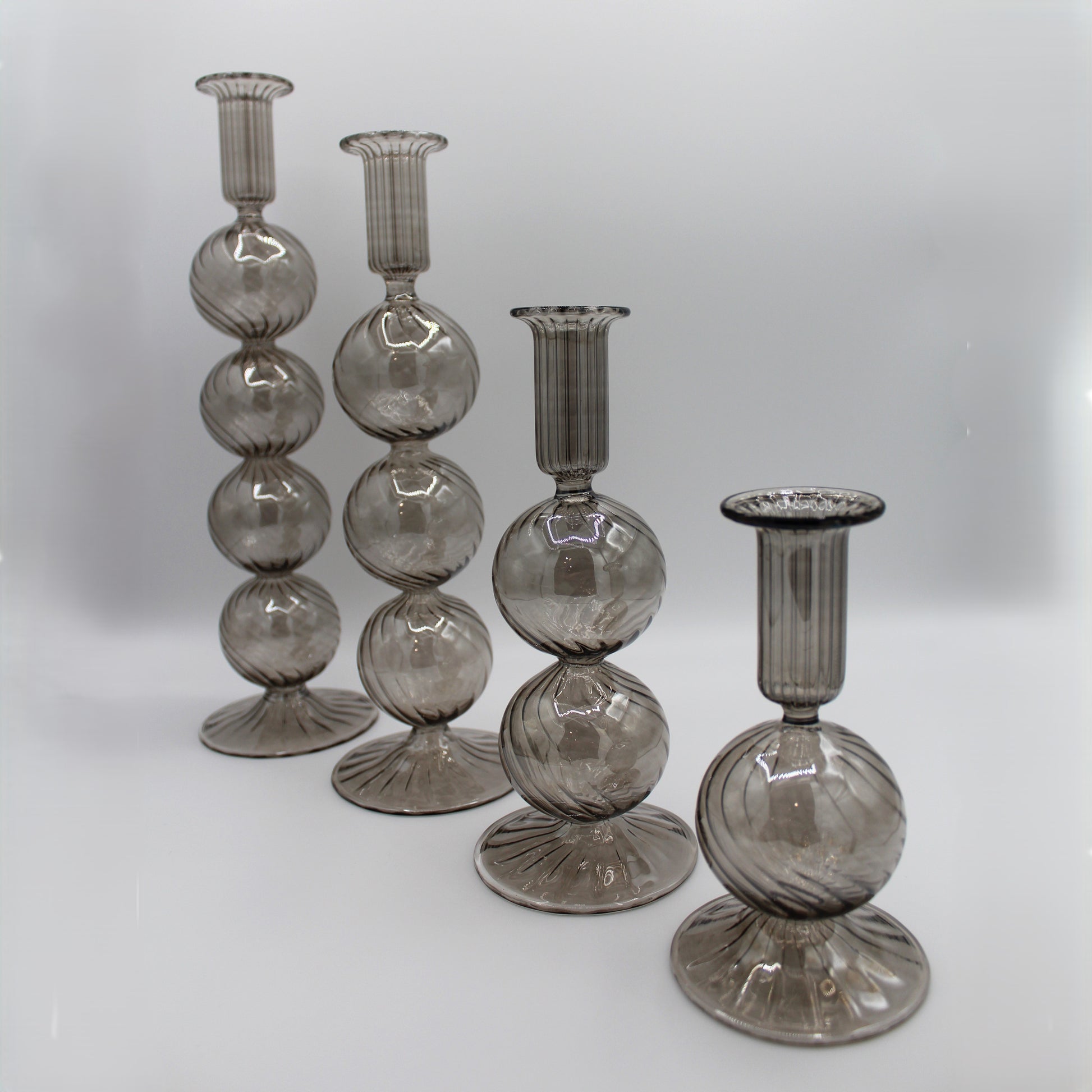 Decorative handblown glass long stem candle holders with baubles in smoky, centerpiece