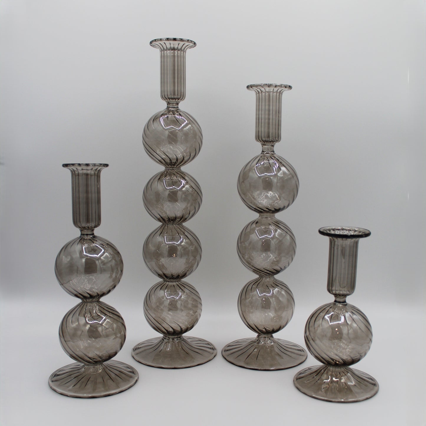 Decorative handblown glass long stem candle holders with baubles in smoky, centerpiece