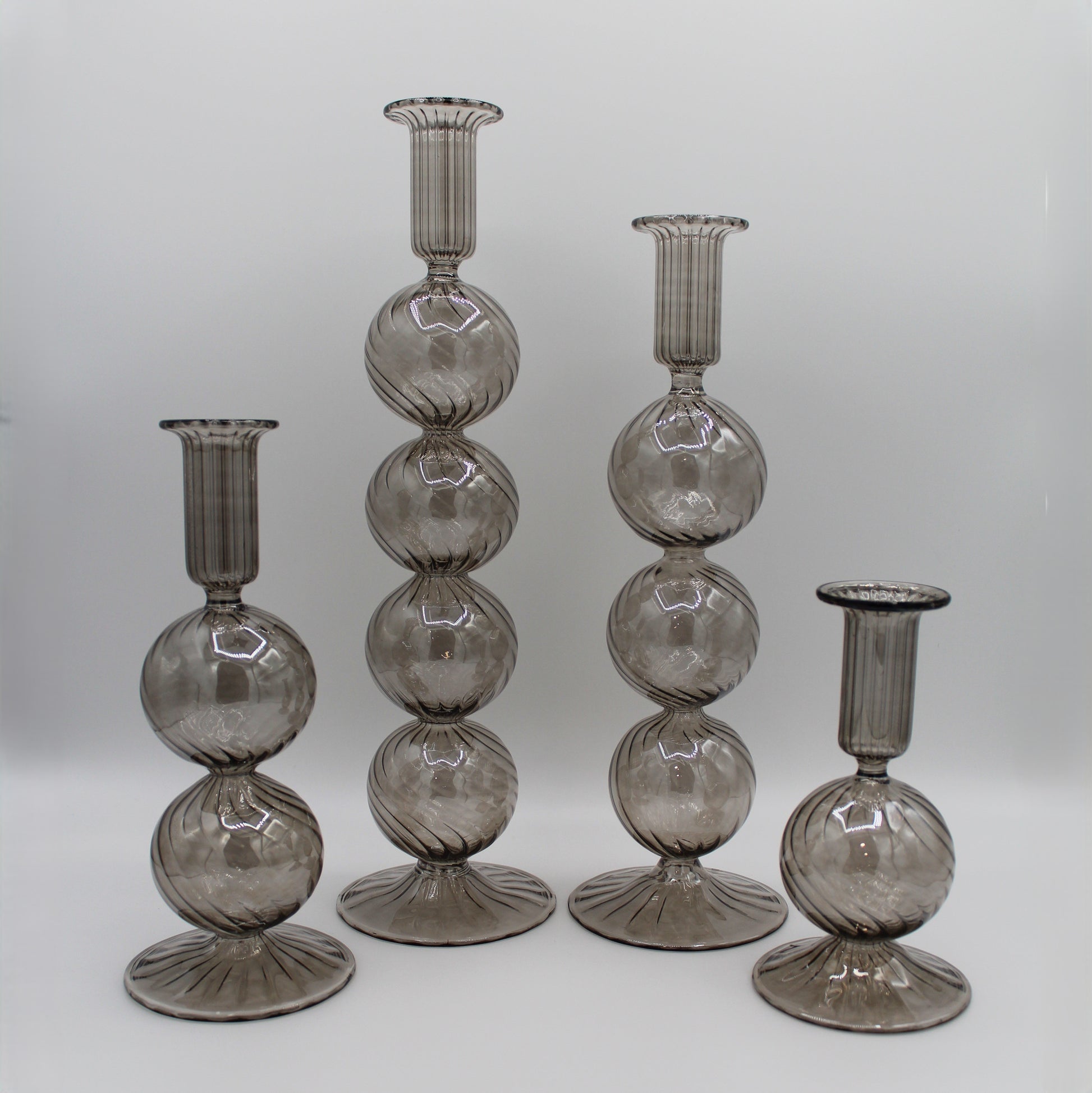 Decorative handblown glass long stem candle holders with baubles in smoky, centerpiece