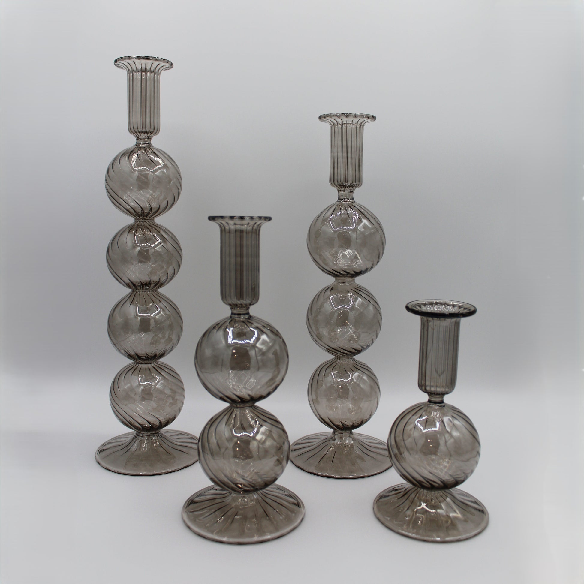 Decorative handblown glass long stem candle holders with baubles in smoky, centerpiece