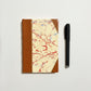 Handbound notebook journal with marbled cover and dark blue leather spine and corners, fair trade