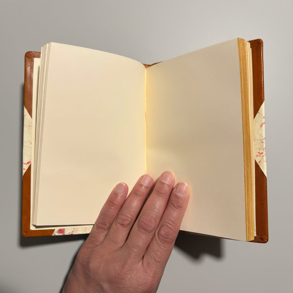 Handbound notebook journal with marbled cover and dark blue leather spine and corners, fair trade