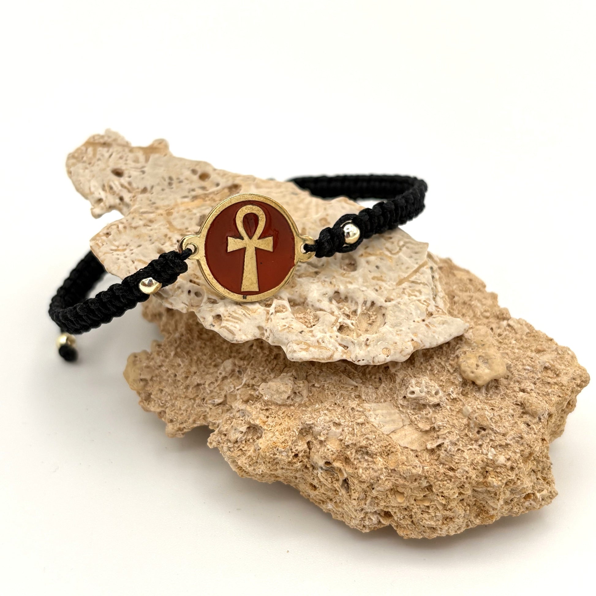 Bracelet with a maroon red medallion featuring a gold ankh symbol, handmade of brass