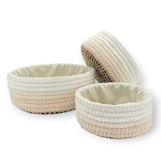 Set of three neutral colored upcycled textile crochet baskets with textured surfaces