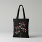 Handmade black tote bag with hand-embroidered fuchsia and pink hydrangea, fair trade