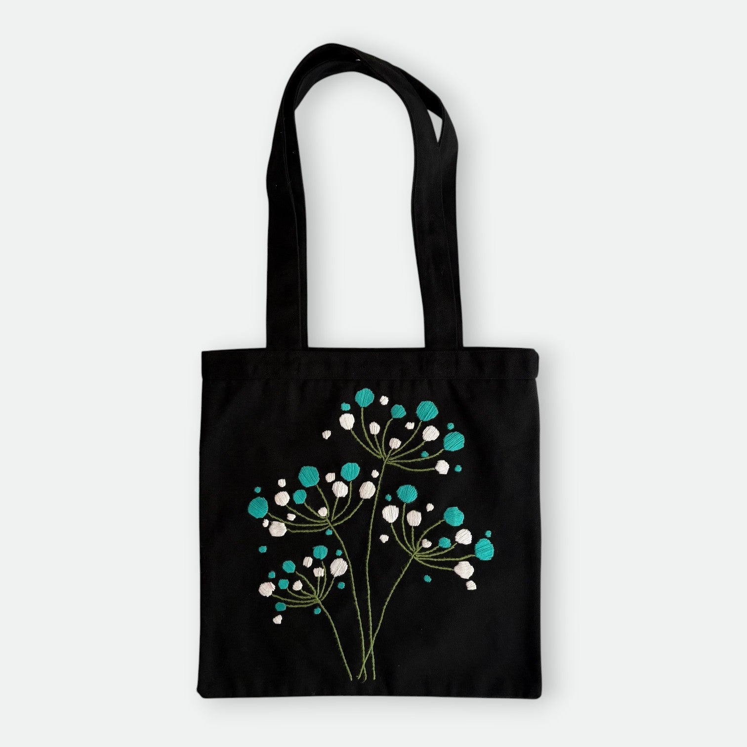 Handmade black tote bag with hand-embroidered white and turquoise hydrangea, fair trade