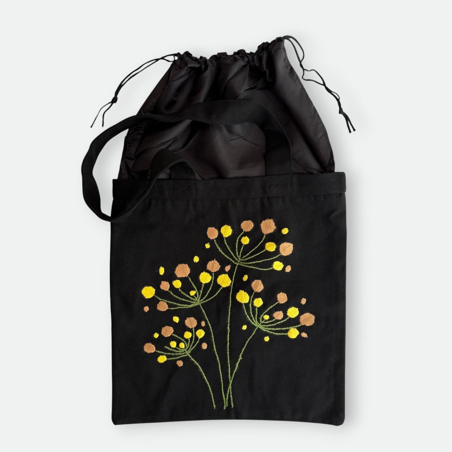 Handmade black tote bag with hand-embroidered yellow and orange hydrangea, fair trade