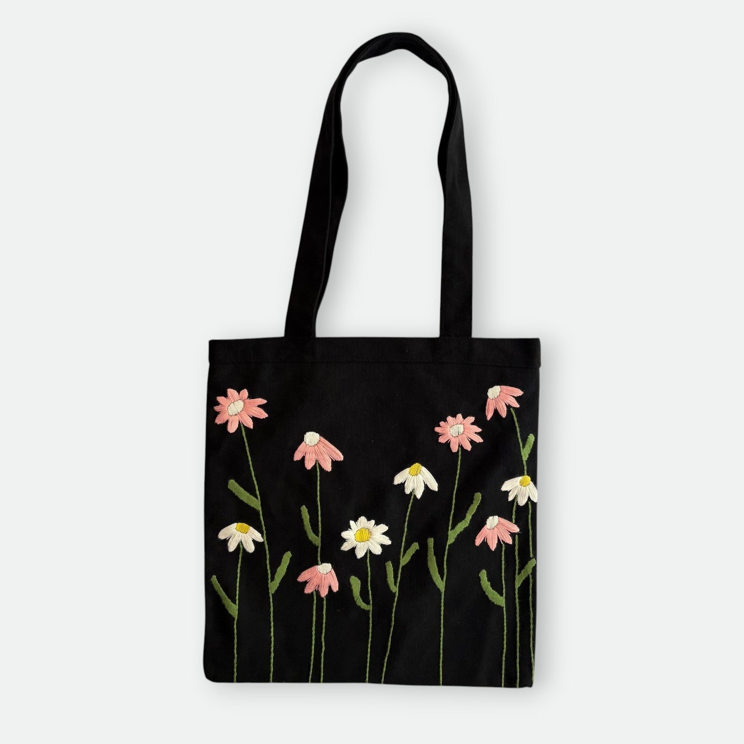 Handmade black tote bag with hand-embroidered pink and white marguerite, fair trade