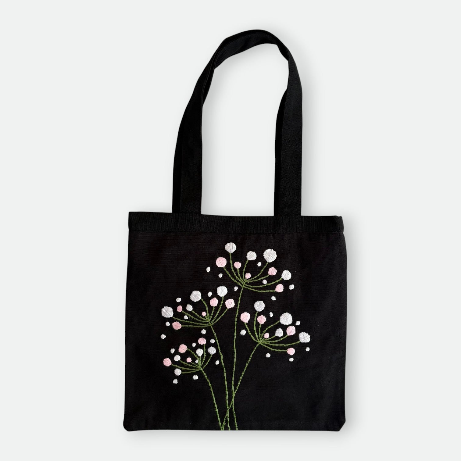 Handmade black tote bag with hand-embroidered white hydrangea, fair trade