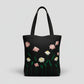 Handmade black tote bag with hand-embroidered pink and white marguerite, fair trade
