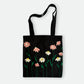 Handmade black tote bag with hand-embroidered pink and white marguerite, fair trade