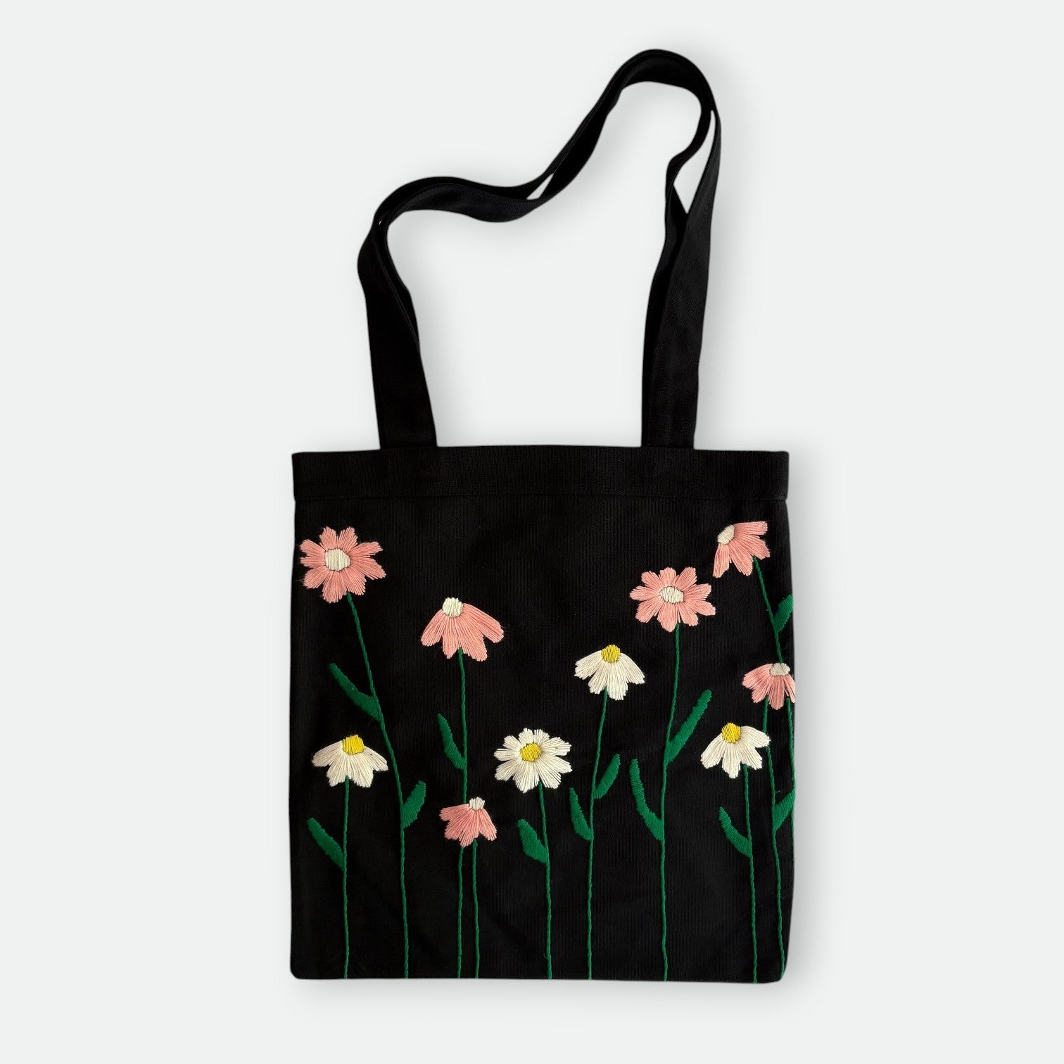Handmade black tote bag with hand-embroidered pink and white marguerite, fair trade