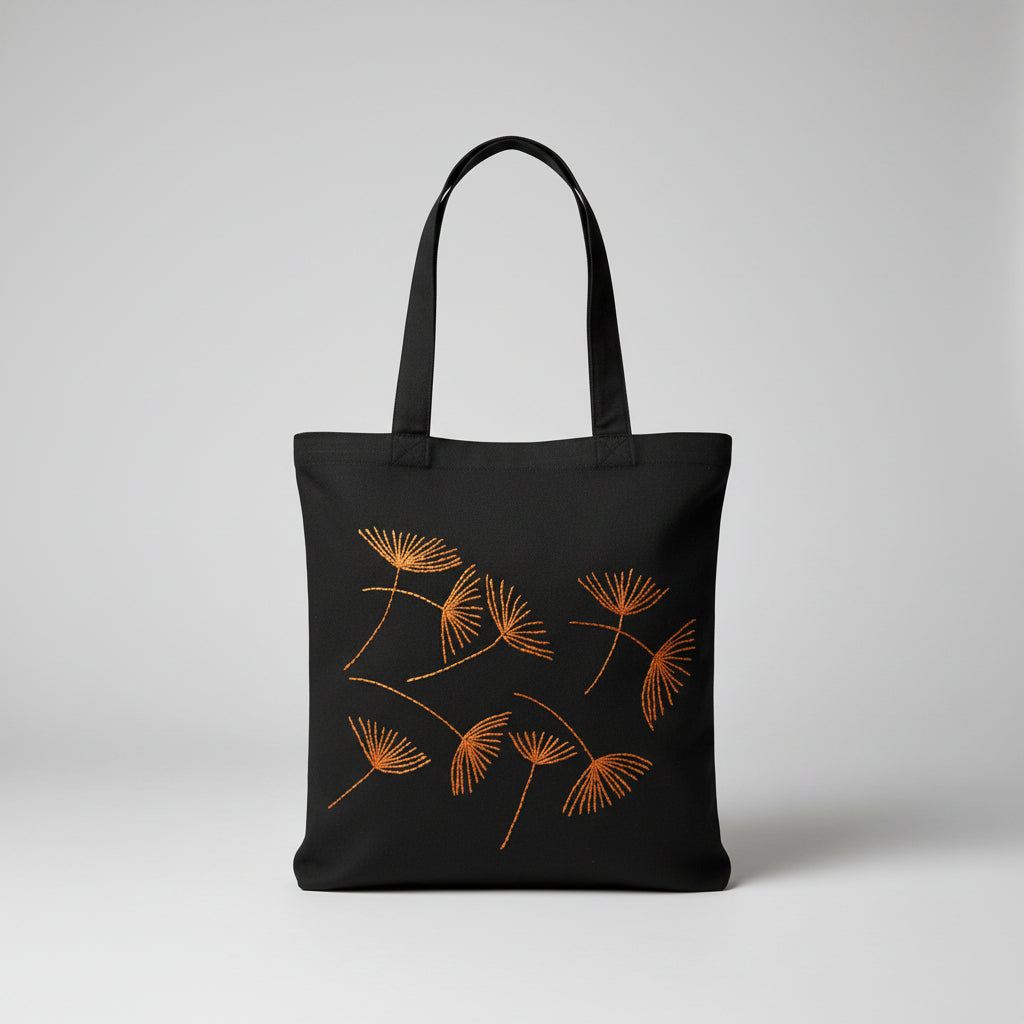 Black canvas tote bag with hand-embroidered orange papyrus design, fair trade handmade