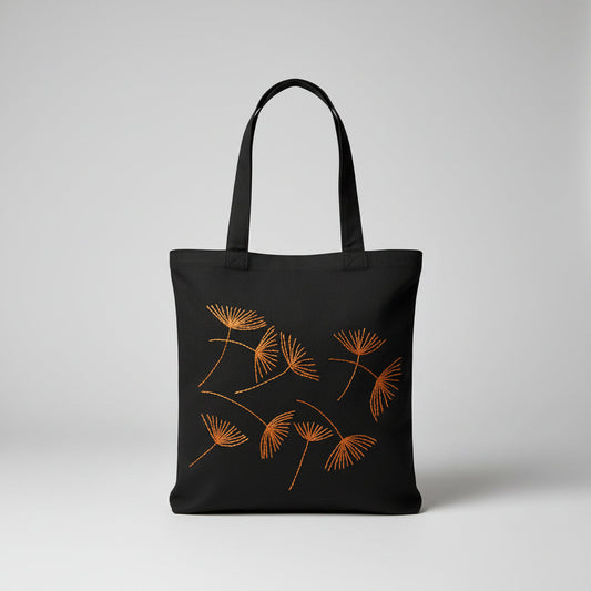 Black canvas tote bag with hand-embroidered orange papyrus design, fair trade handmade