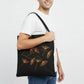 Black canvas tote bag with hand-embroidered orange papyrus design, fair trade handmade