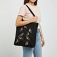 Black canvas tote bag with hand-embroidered pink papyrus design, fair trade handmade