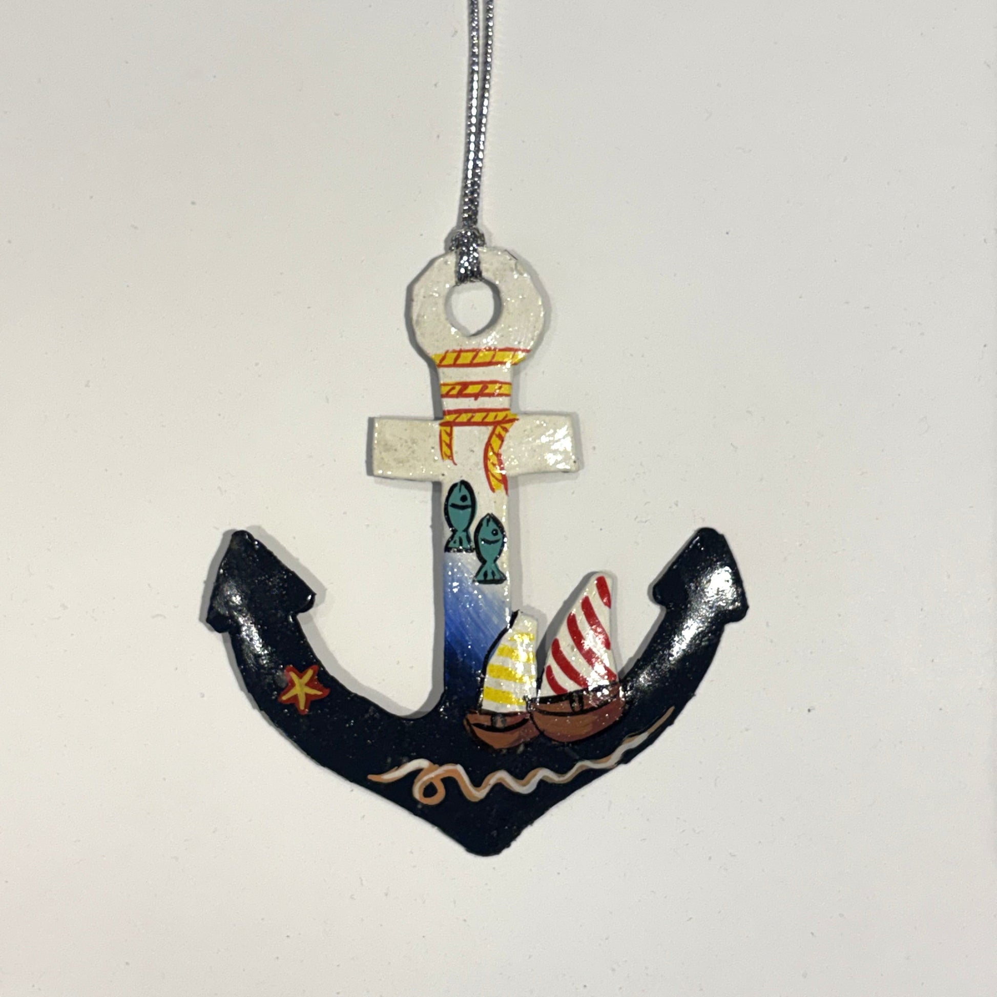 Fair trade handcrafted upcycled metal anchor ornament with a sailboat and fish design, artisan-made, sustainable decor