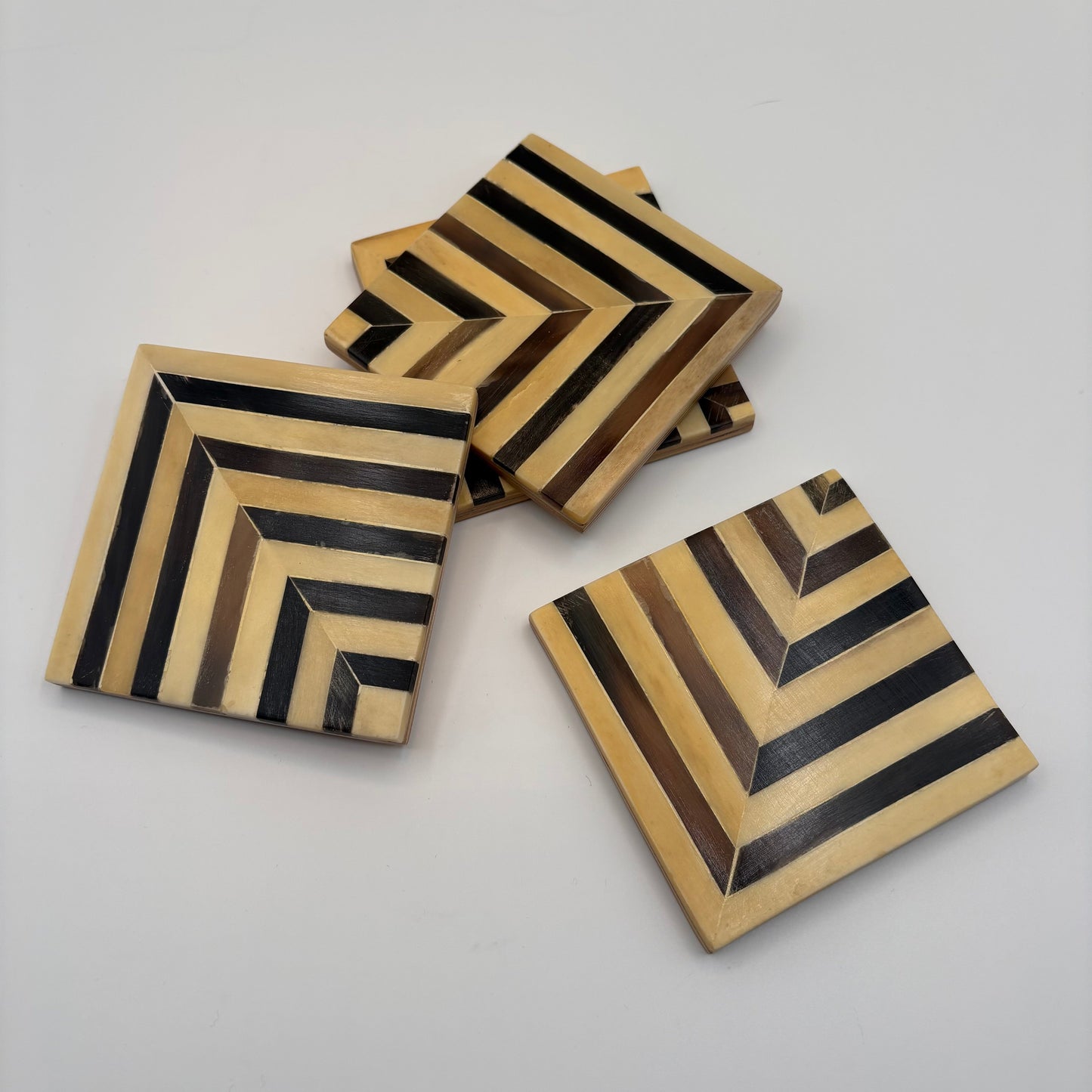 Set of 4 wooden coasters inlaid with camel bone with dark brown and beige chevron pattern, fair trade