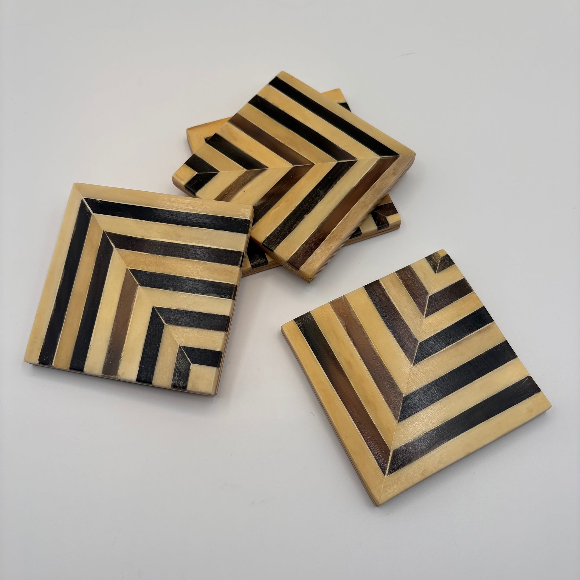 Set of 4 wooden coasters inlaid with camel bone with dark brown and beige chevron pattern, fair trade