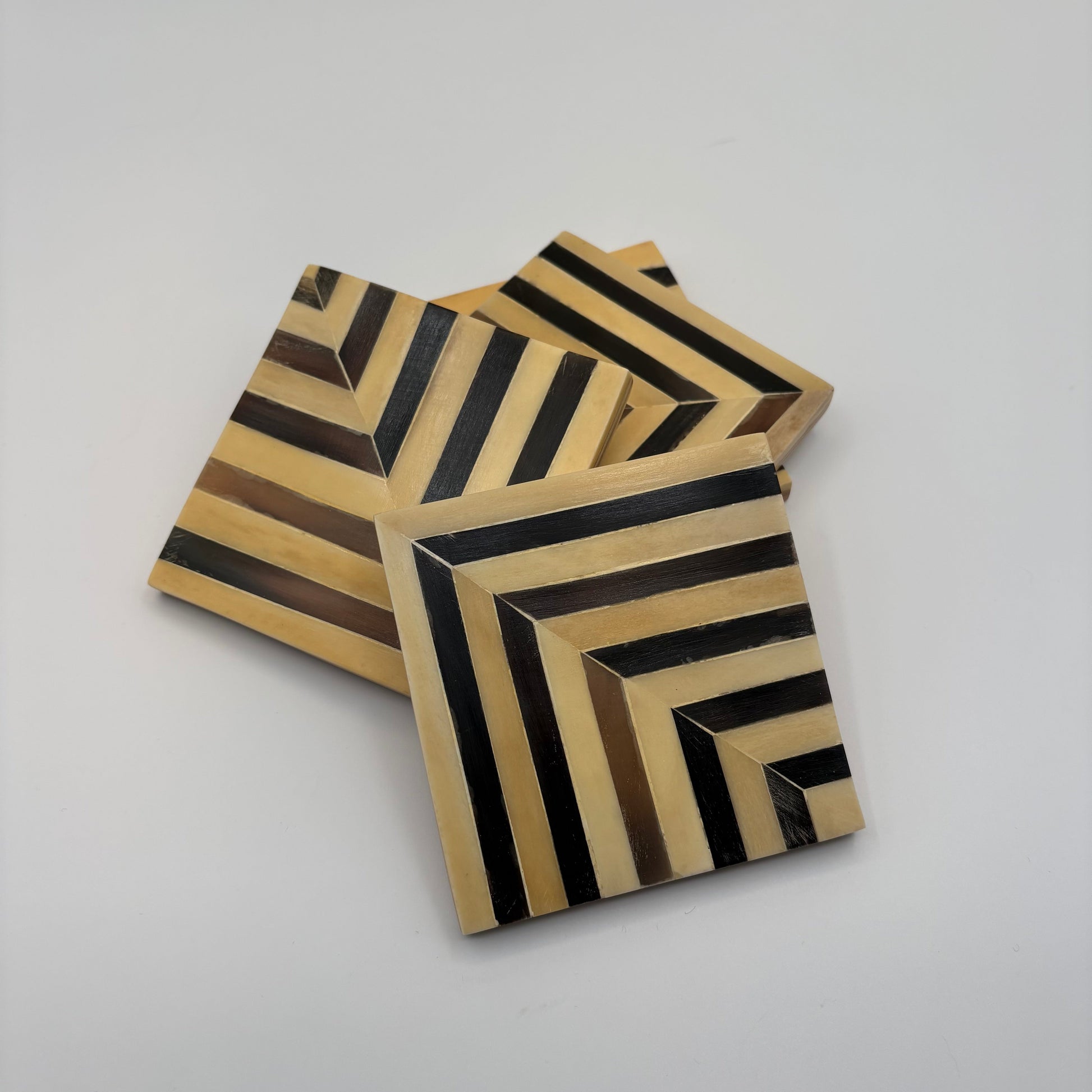 Set of 4 wooden coasters inlaid with camel bone with dark brown and beige chevron pattern, fair trade