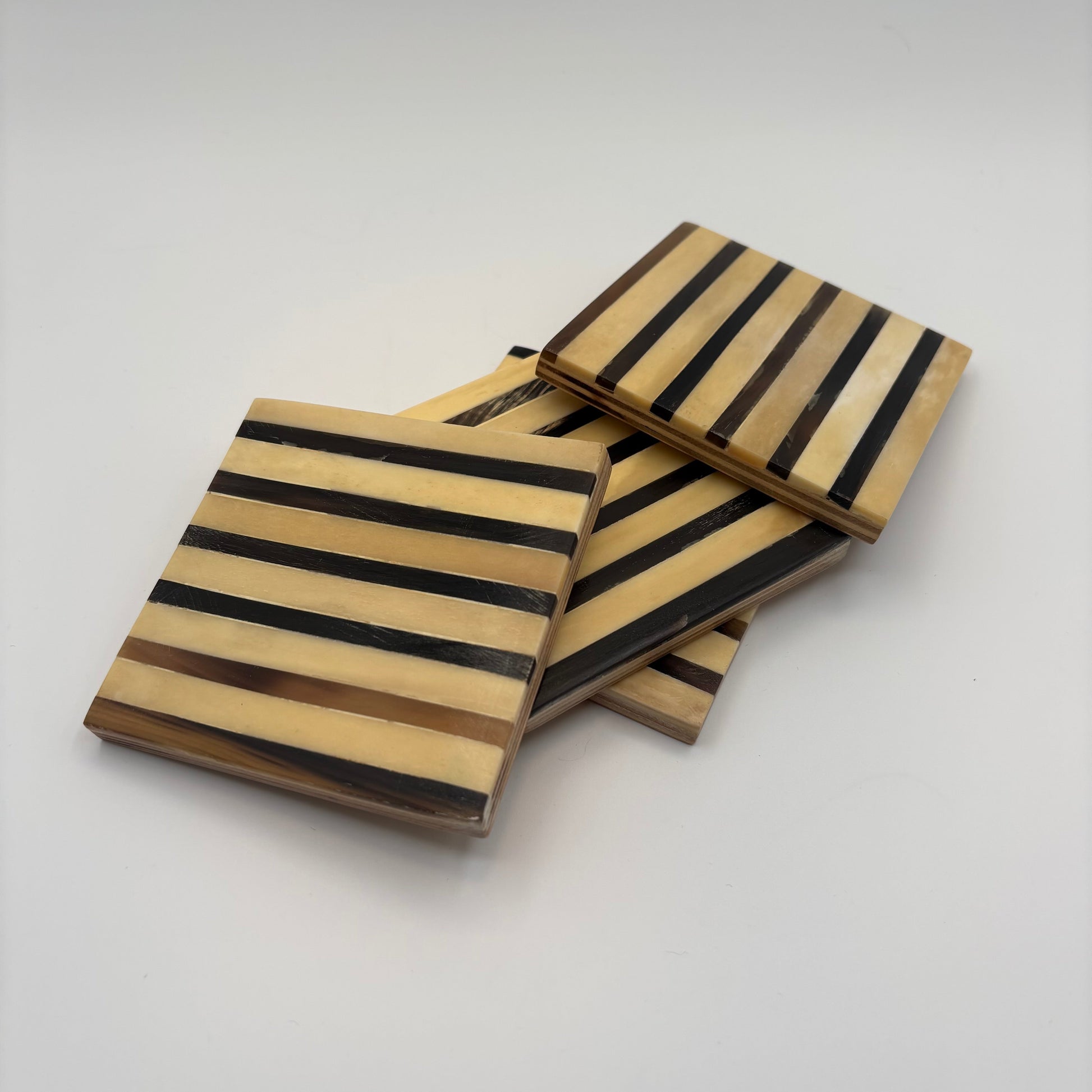 Set of 4 wooden coasters inlaid with camel bone with dark brown and beige stripe pattern, fair trade