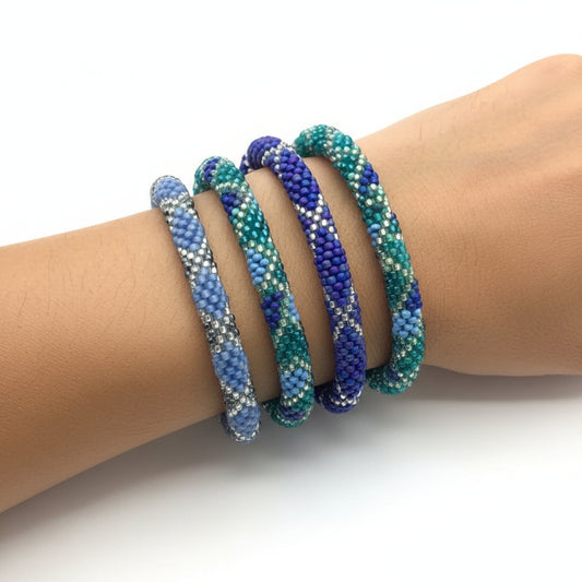 Hand-beaded bracelets in various shades of blue and teal, ethically handmade by women artisans of glass beads, fair trade